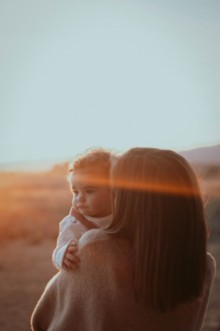 Madre e hija compartiendo un momento mágico al atardecer en Villena, envueltas por la cálida luz de la puesta de sol