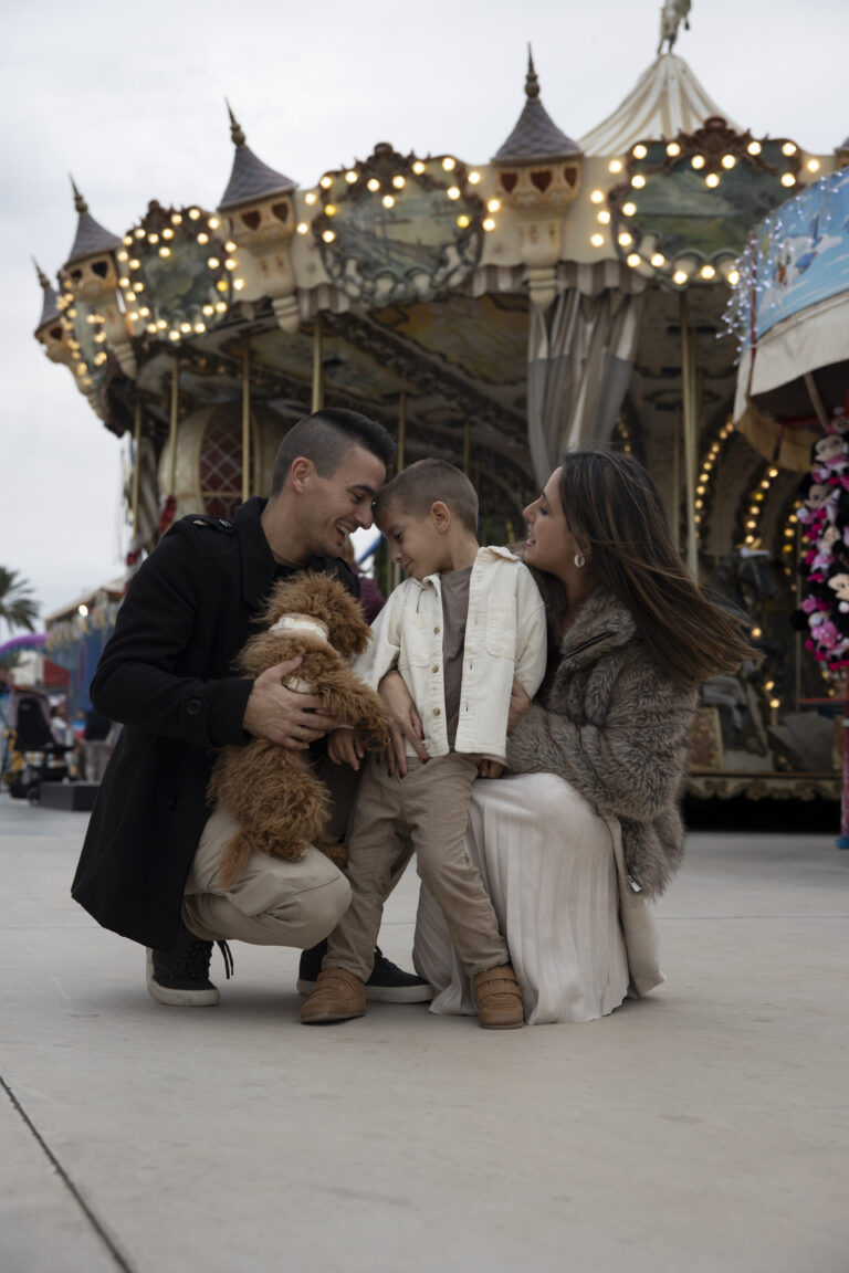 Padres, hijo y su mascota compartiendo momentos de alegría entre las atracciones de la Feria de Alicante